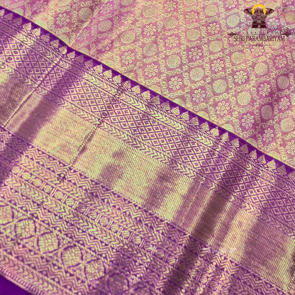 A Soft pastel peach with rich gold zari work and a contrasting deep magenta (rani pink) border Saree