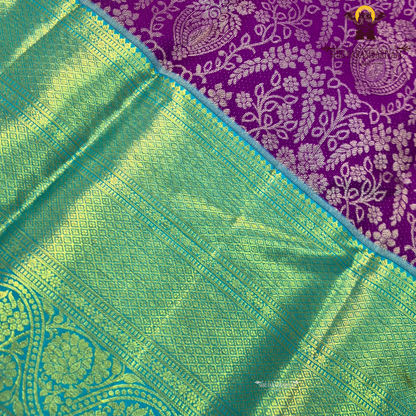 A rich violet purple body with a contrasting sky blue korvai border Saree