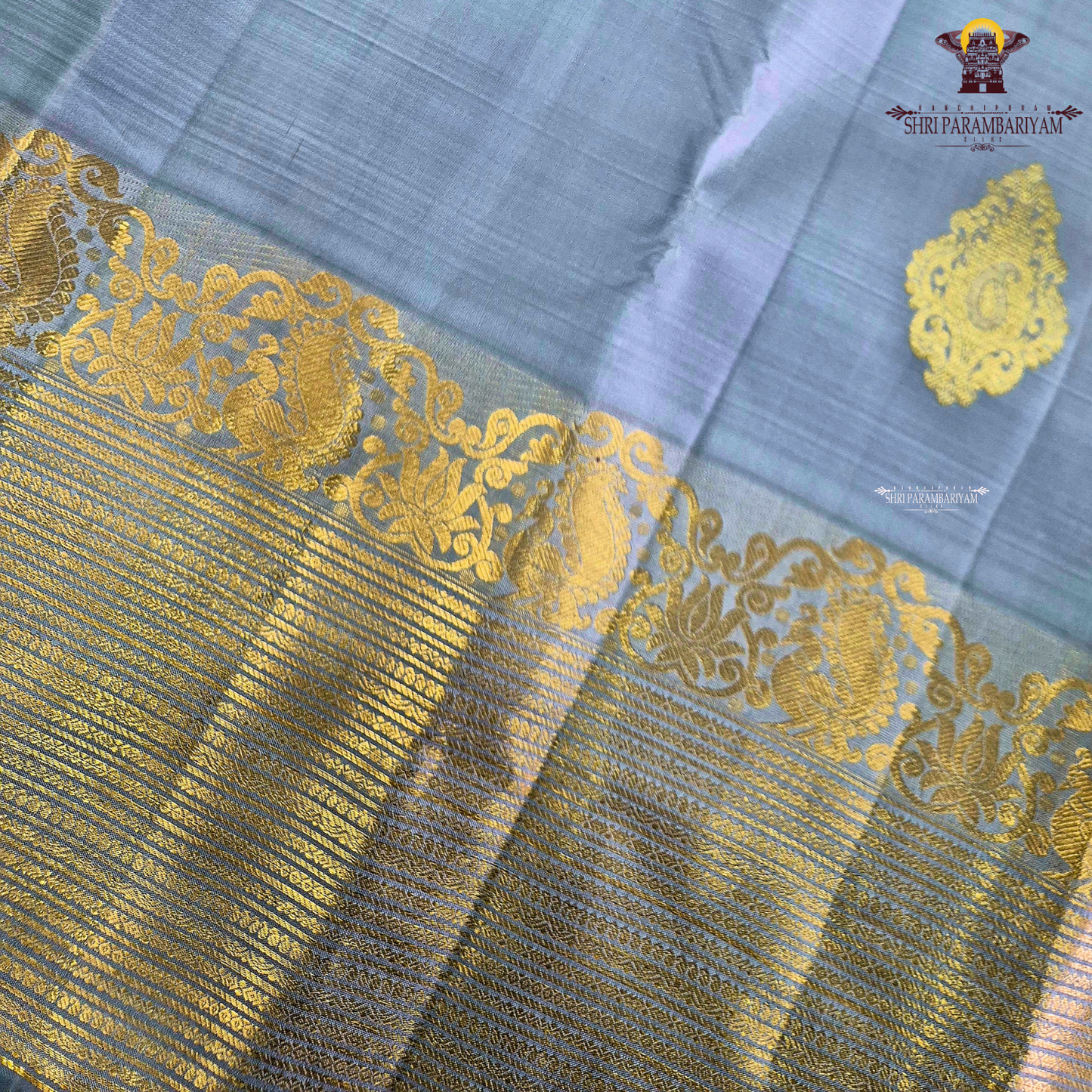 A soothing Ice Blue shade, adorned with graceful gold zari floral buttas Saree