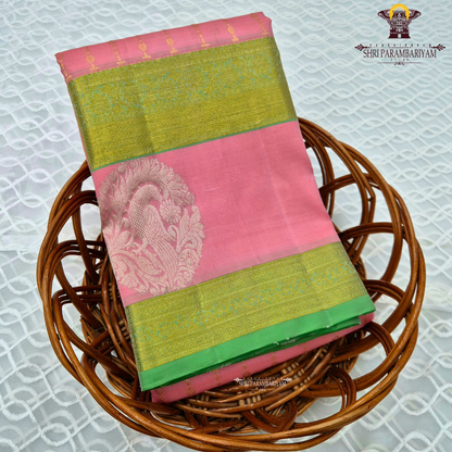 A graceful soft pink body complemented by a rich parrot green contrast border Saree