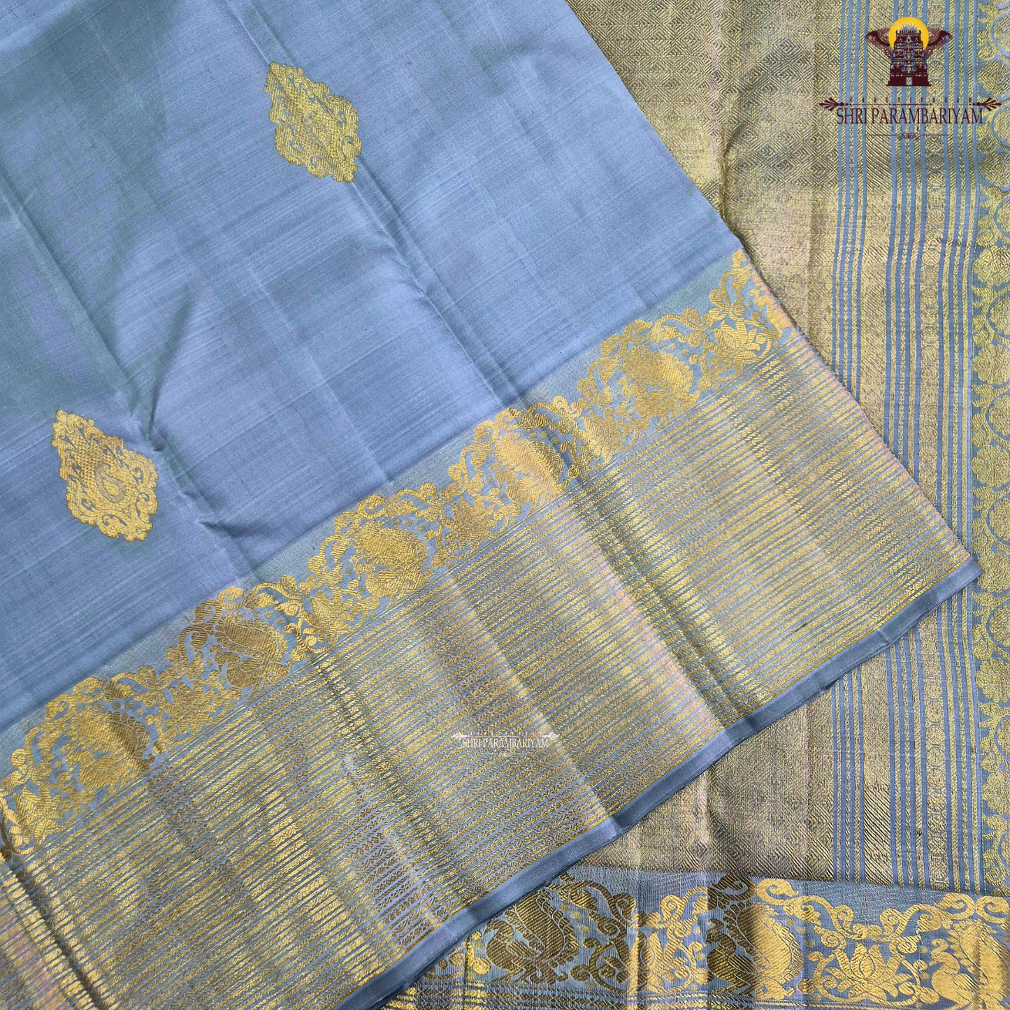A soothing Ice Blue shade, adorned with graceful gold zari floral buttas Saree