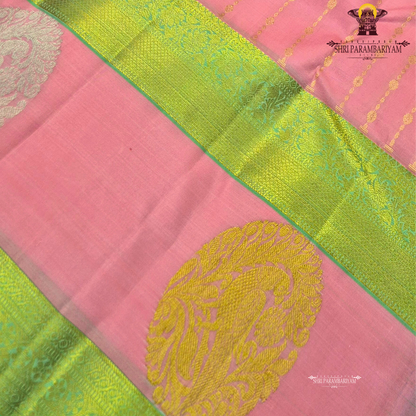 A graceful soft pink body complemented by a rich parrot green contrast border Saree