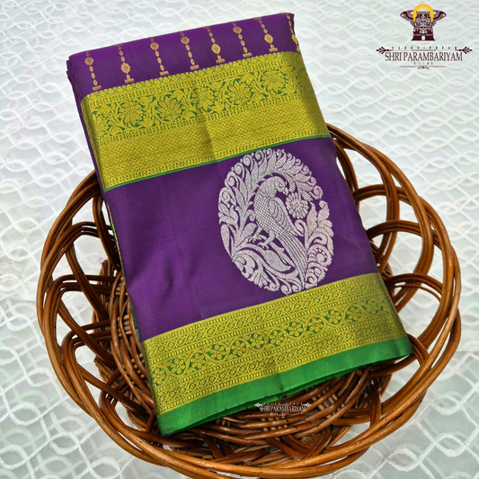 A rich royal purple body beautifully complemented by a vibrant parrot green contrast border Saree