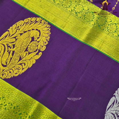 A rich royal purple body beautifully complemented by a vibrant parrot green contrast border Saree