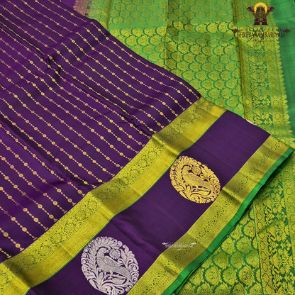 A rich royal purple body beautifully complemented by a vibrant parrot green contrast Saree