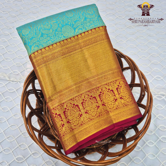 A beautiful aqua blue body with elegant floral zari weaving, paired with a rich golden Saree