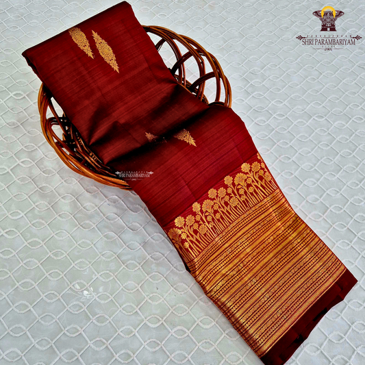 A vibrant Ruby Red shade, elegantly adorned with traditional gold zari buttas Saree