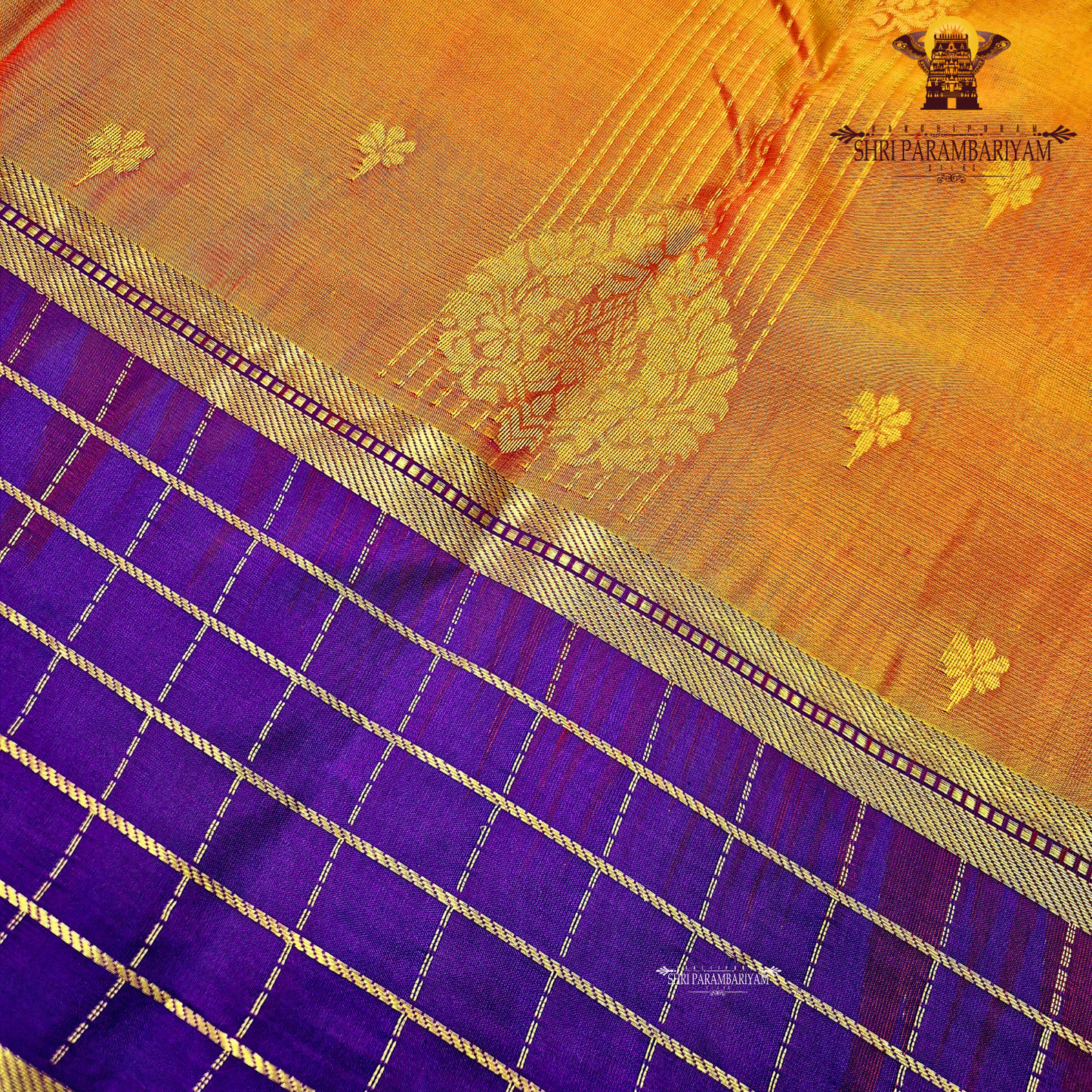 A rich mustard orange body paired beautifully with a deep royal purple pallu and border Saree