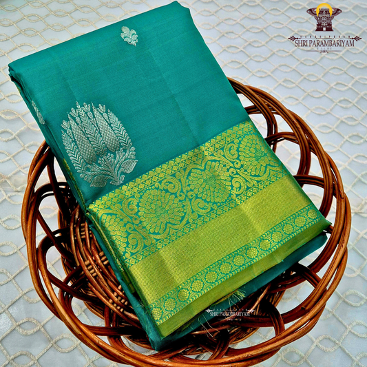 Rich teal green (peacock green tone) with a contrast gold zari border featuring a parrot green shade Saree