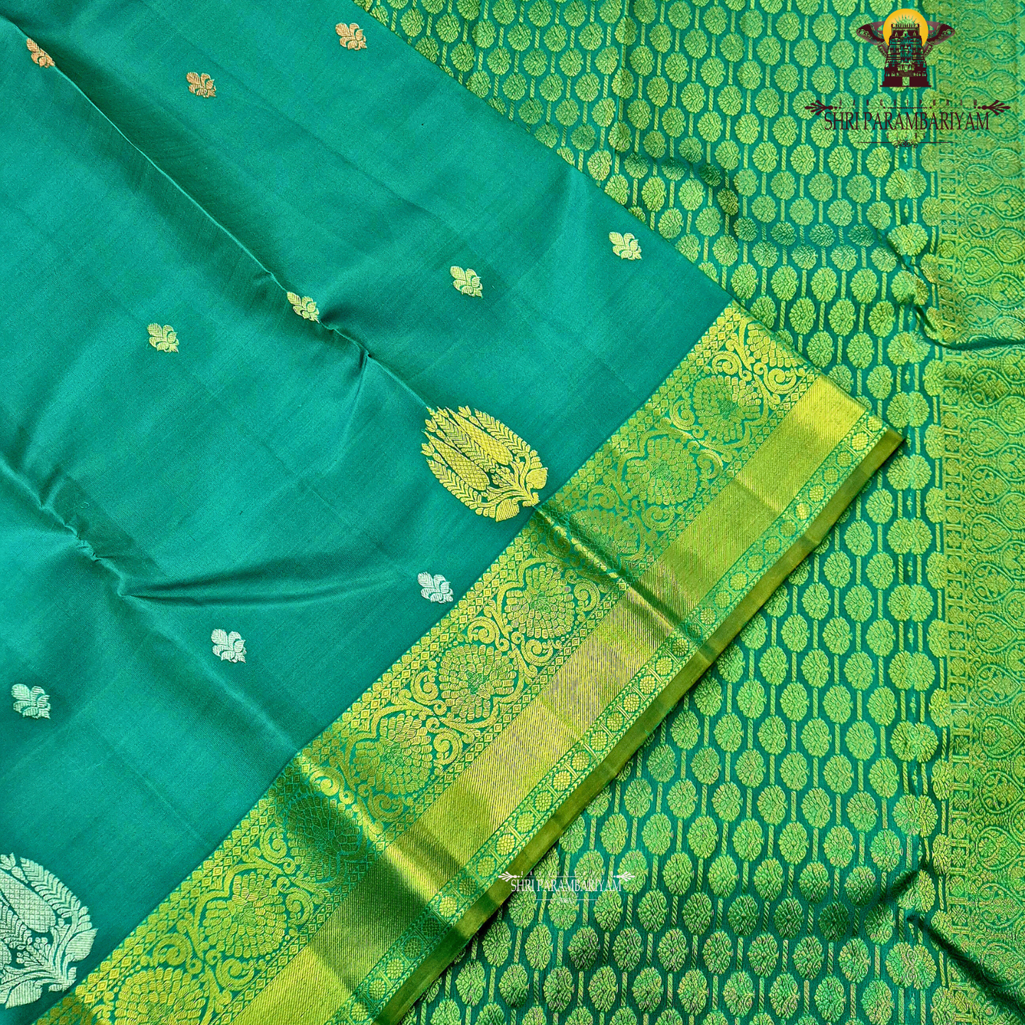 Rich teal green (peacock green tone) with a contrast gold zari border featuring a parrot green shade Saree