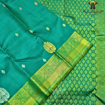 Rich teal green (peacock green tone) with a contrast gold zari border featuring a parrot green shade Saree