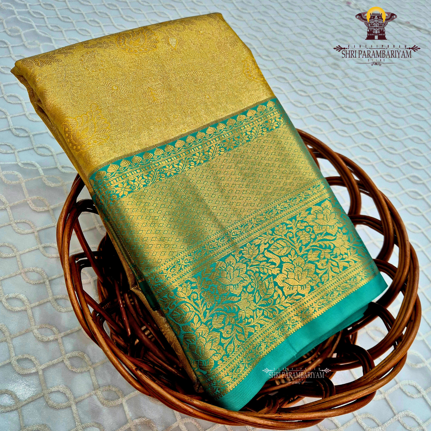 Elegant antique gold body paired with a rich teal green border Saree