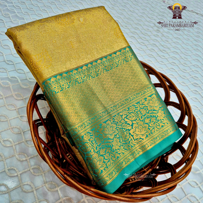 Elegant antique gold body paired with a rich teal green border Saree