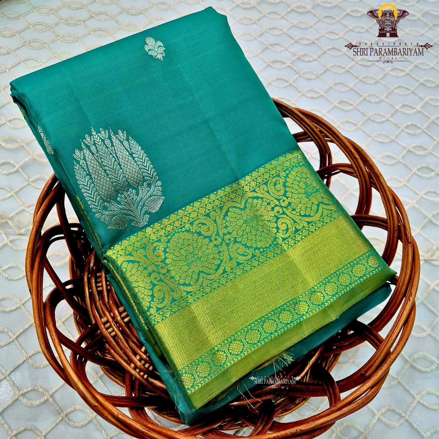 Rich teal green (peacock green tone) with a contrast gold zari border featuring a parrot green shade Saree