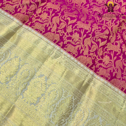 A vibrant deep magenta / rani pink body paired with a rich gold zari Saree