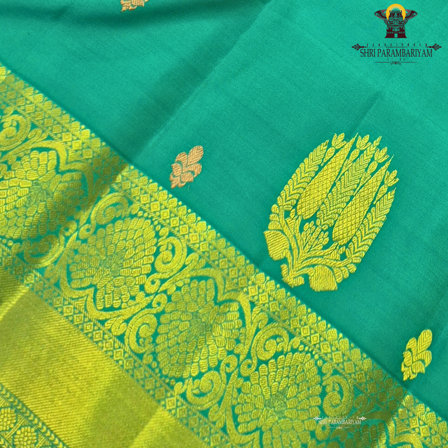 Rich teal green (peacock green tone) with a contrast gold zari border featuring a parrot green shade Saree