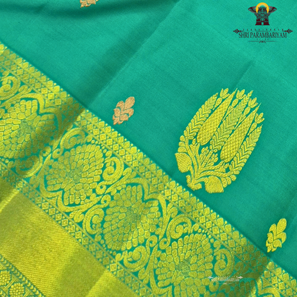 Rich teal green (peacock green tone) with a contrast gold zari border featuring a parrot green shade Saree