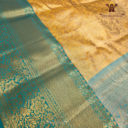 Elegant antique gold body paired with a rich teal green border Saree