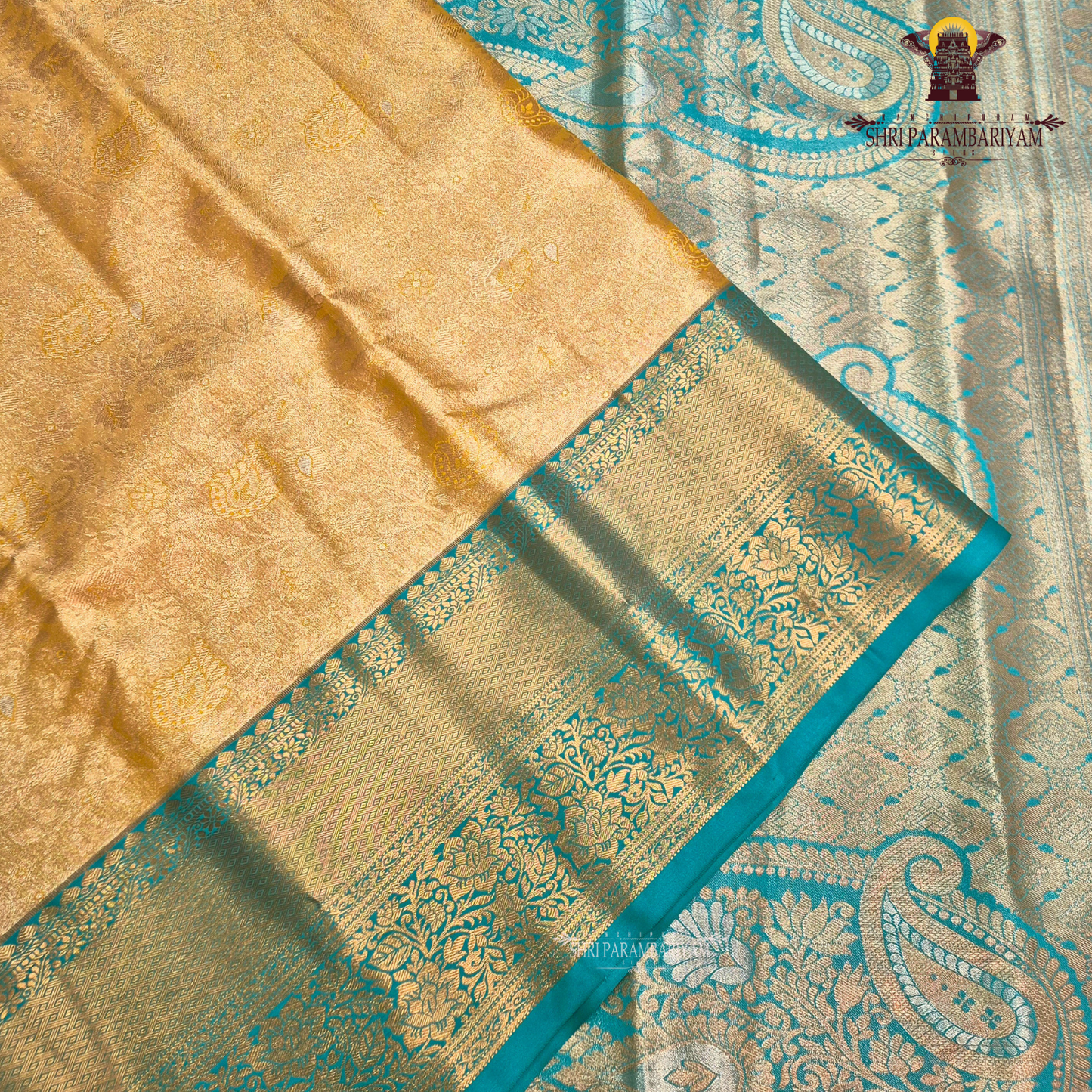 Elegant antique gold body paired with a rich teal green border Saree
