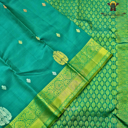 Rich teal green (peacock green tone) with a contrast gold zari border featuring a parrot green shade Saree