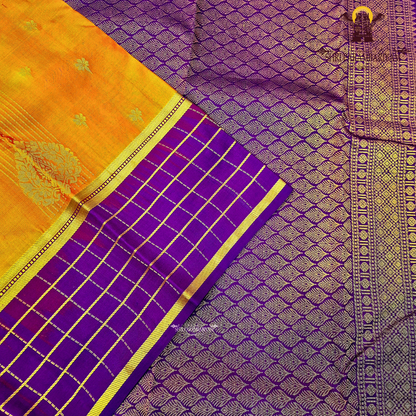 A rich mustard orange body paired beautifully with a deep royal purple pallu and border Saree