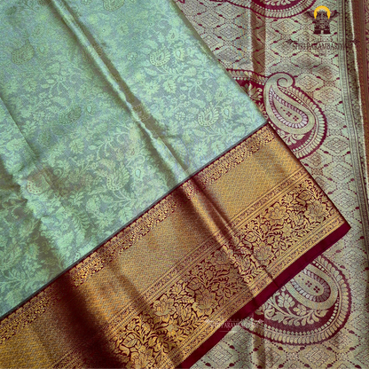 Classic champagne gold body paired with a rich brick red border Saree