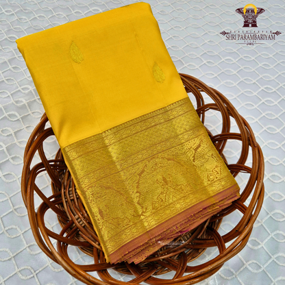 A bright turmeric yellow with rich gold zari border and a subtle maroon edging Saree
