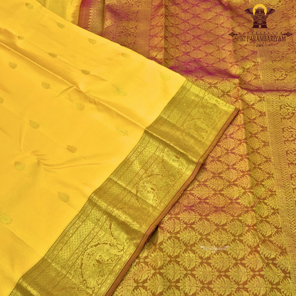 A bright turmeric yellow with rich gold zari border and a subtle maroon edging Saree