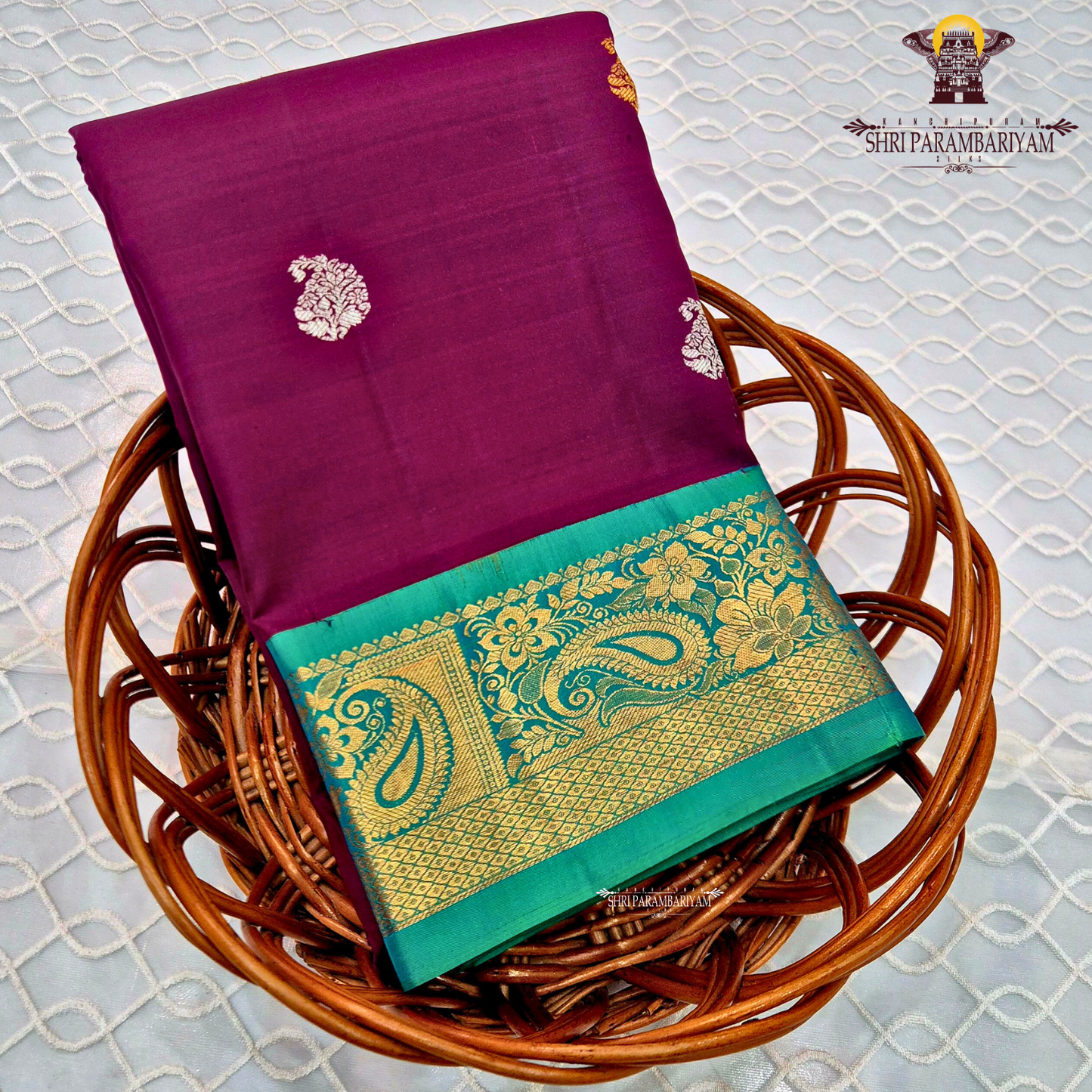 A rich deep magenta (pinkish-maroon) body paired with a peacock green border Saree