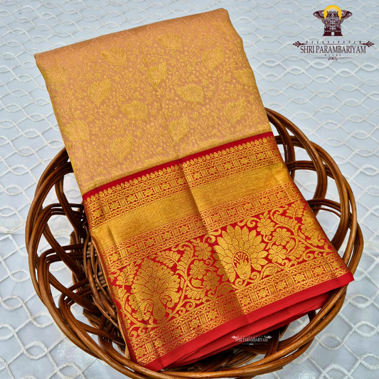 A soft pastel peach body paired with a rich deep red korvai border Saree