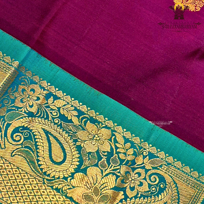 A rich deep magenta (pinkish-maroon) body paired with a peacock green border Saree