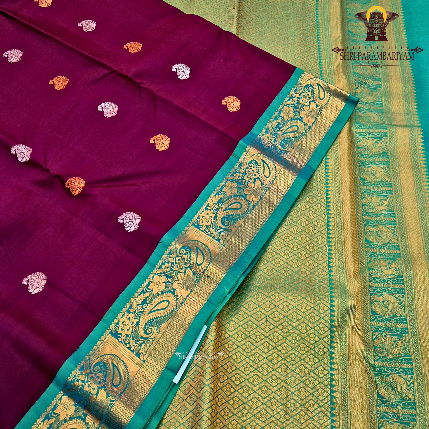 A rich deep magenta (pinkish-maroon) body paired with a peacock green border Saree