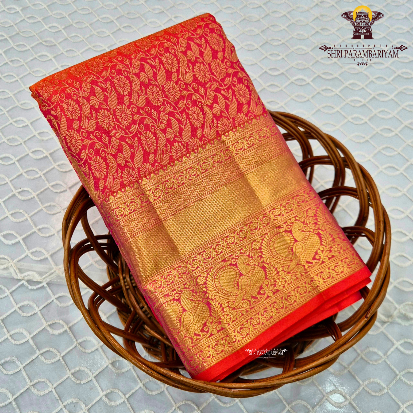 A vibrant reddish orange and pink combination with a radiant gold zari Saree