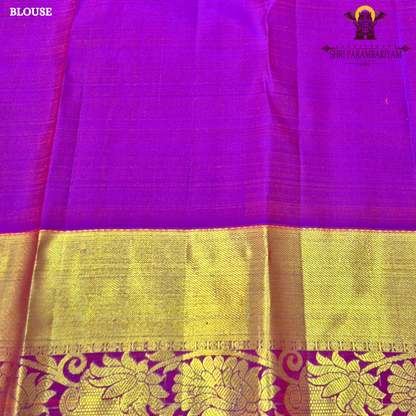 A vibrant red with rich gold zari border and contrast purple edging Saree