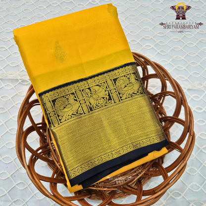 A bright turmeric yellow body paired with a deep navy blue border richly woven Saree