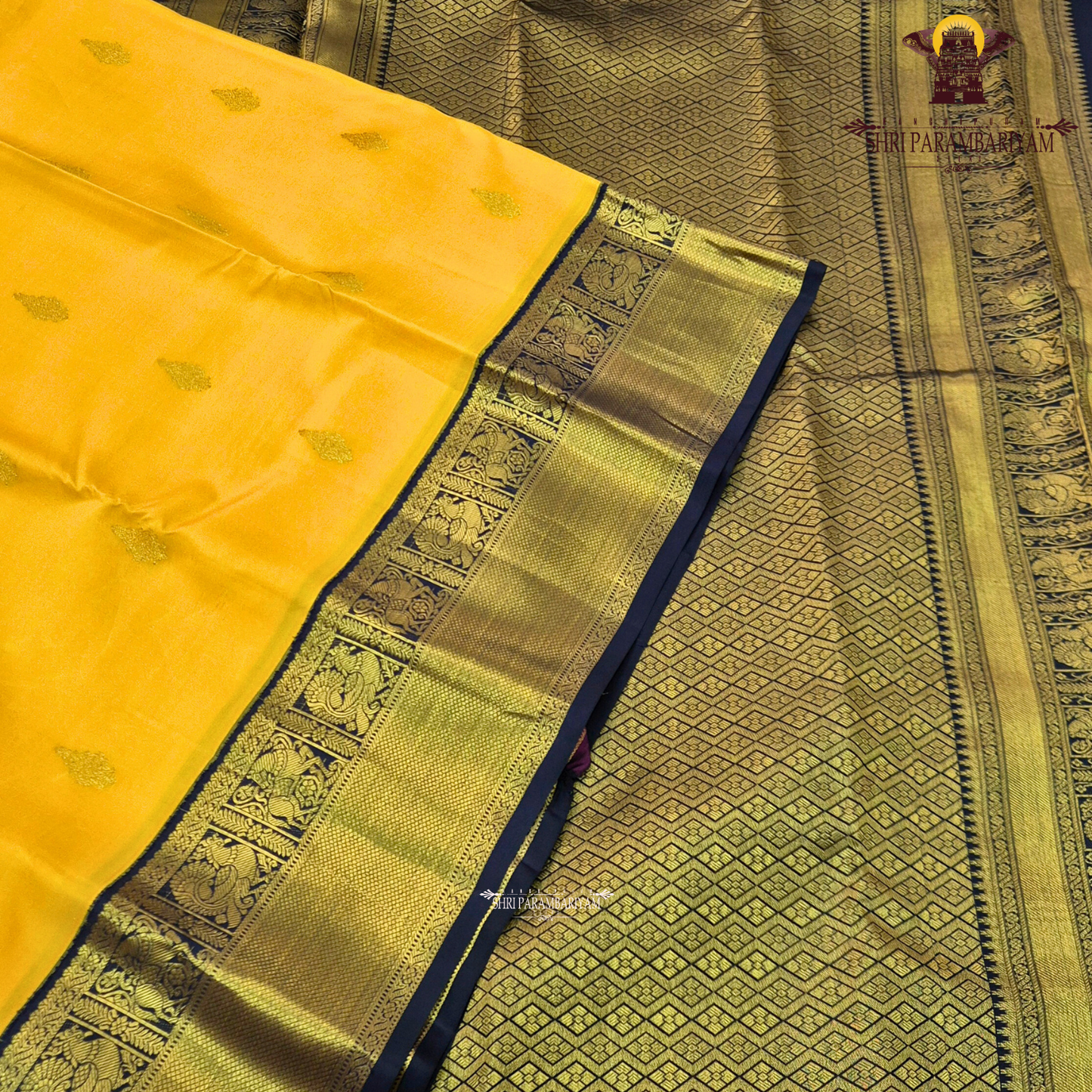 A bright turmeric yellow body paired with a deep navy blue border richly woven Saree