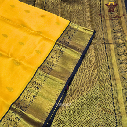 A bright turmeric yellow body paired with a deep navy blue border richly woven Saree