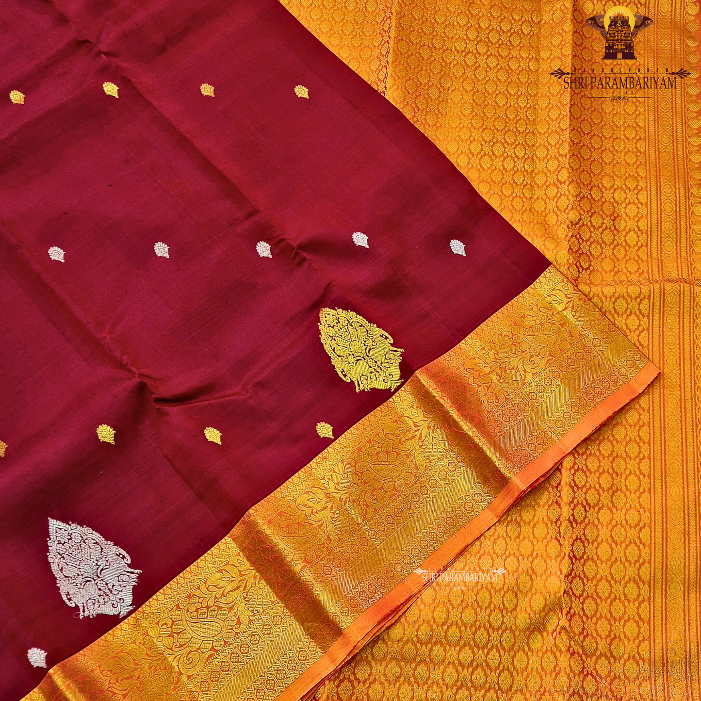 Deep maroon (wine red tone) with a rich contrast of golden zari and orange-toned border Saree