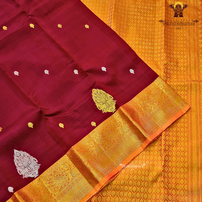 Deep maroon (wine red tone) with a rich contrast of golden zari and orange-toned border Saree