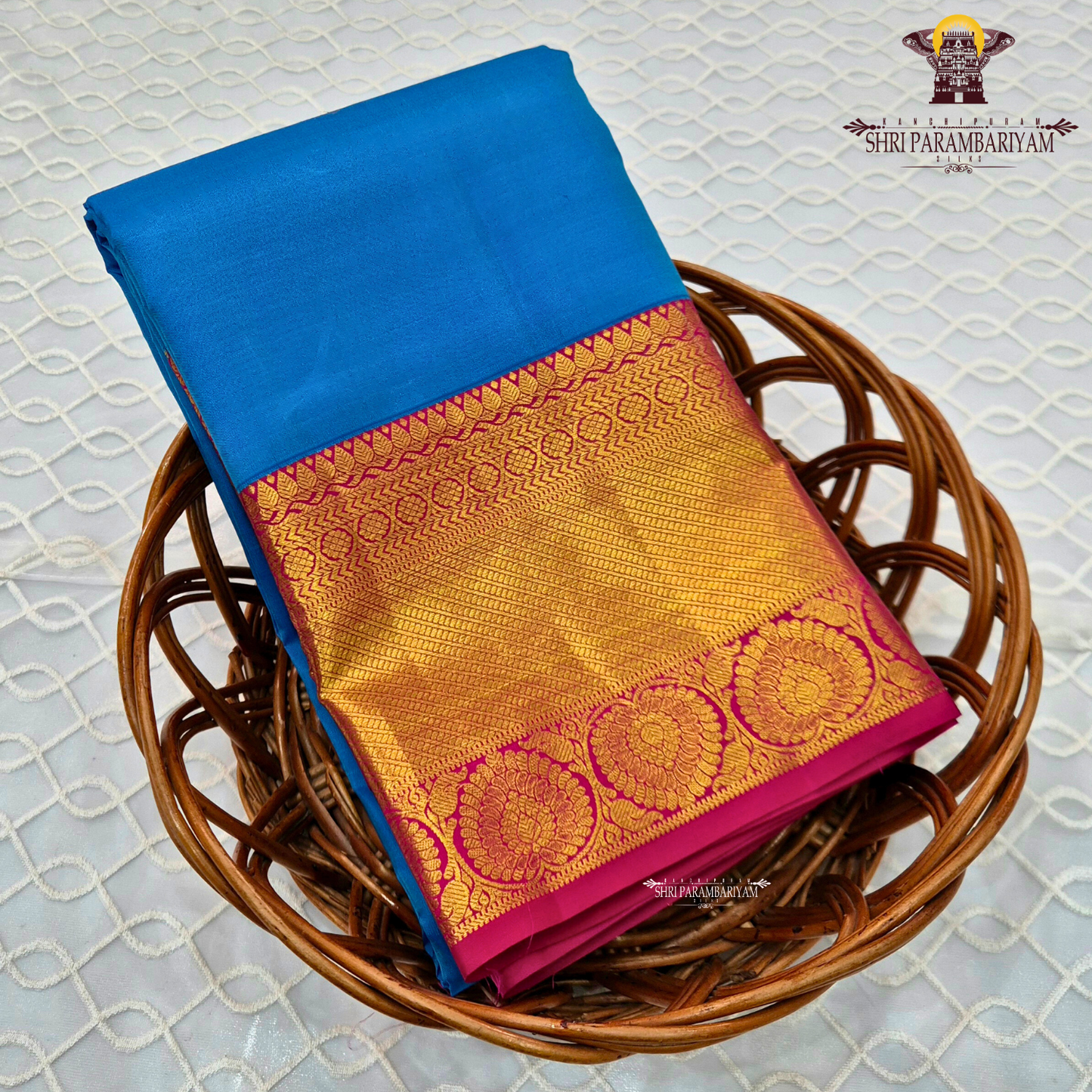 A bright turquoise blue body paired with a rich magenta pink border intricately woven Saree