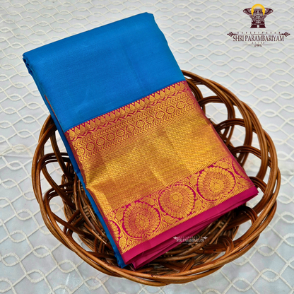 A bright turquoise blue body paired with a rich magenta pink border intricately woven Saree