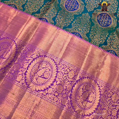 A rich dual-tone combination with a deep teal green body, contrasted Saree
