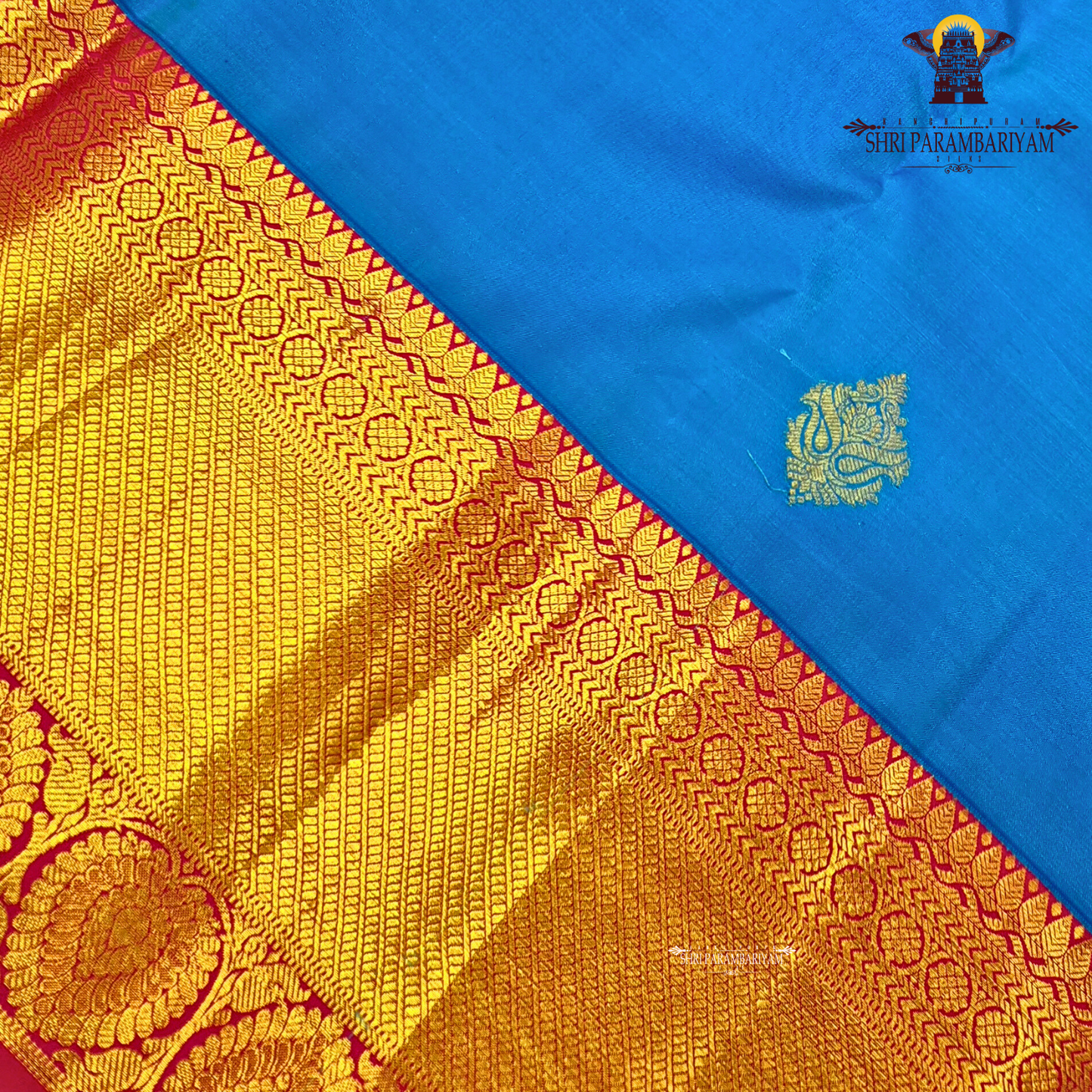 A bright turquoise blue body paired with a rich magenta pink border intricately woven Saree