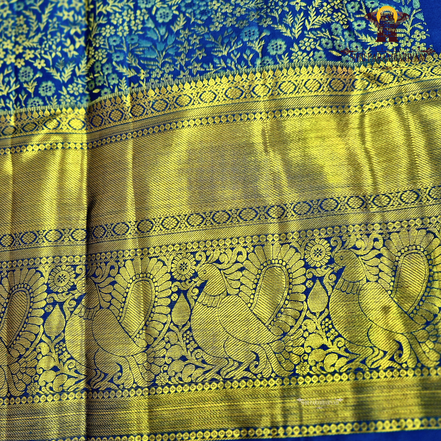 A rich royal blue body paired with an elegant antique gold zari border Saree