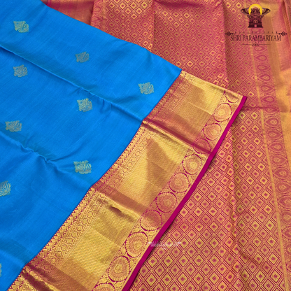A bright turquoise blue body paired with a rich magenta pink border intricately woven Saree