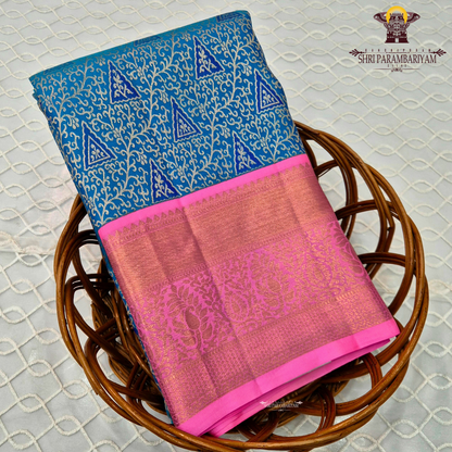 A vibrant peacock blue body paired with a bright pink korvai border Saree