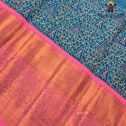 A vibrant peacock blue body paired with a bright pink korvai border Saree