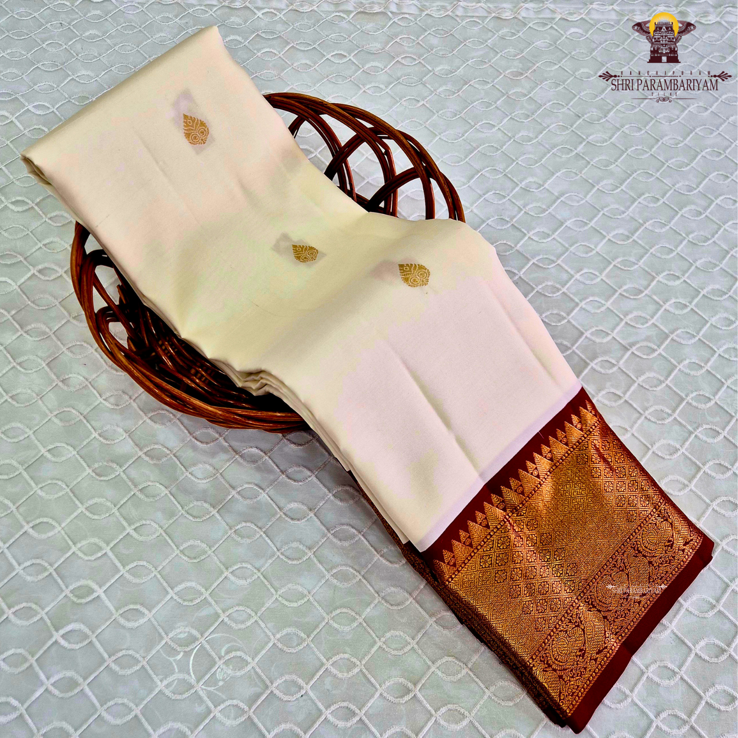 A pristine ivory white body adorned with delicate gold zari Saree
