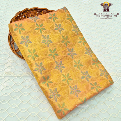 A radiant golden yellow / mustard gold tissue base with subtle pastel green and lavender accents Saree