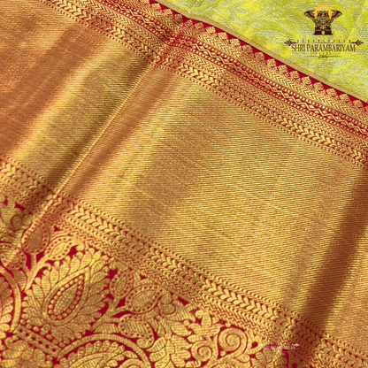 A refreshing lime green body paired with a rich golden tissue pallu and red zari border Saree